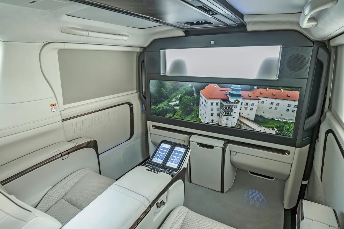 A Lexus LM guruló privát klubhelyiség, 48,0 colos tévével, hűtővel, komfortülésekkel. A középső kartámasz végén a két kivehető vezérlő