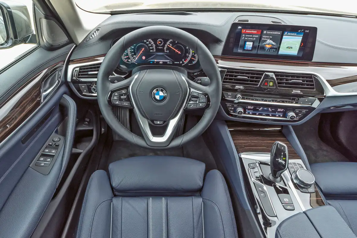 Jó elrendezésű a műszerfal, az iDrive felületére írni is lehet, a rendszer felismeri az ujjal odarajzolt karaktereket. A rögzítőfék minden 5-ösben elektromos, az infotainment online kapcsolattal rengeteget tud (itthon sok funkció nem él), a tartalmat lapozható „csempéken” lehet gyorsan áttekinteni