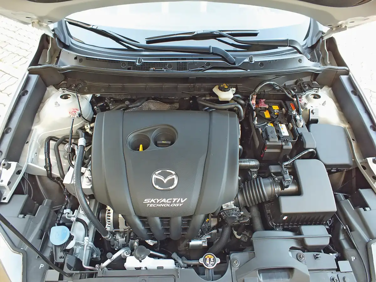 Kitámasztós géptető alatt bújik meg a Mazda jól bevált, magas kompressziójú, csendes négyhengerese. Meglepően takarékos még az automata váltóval is