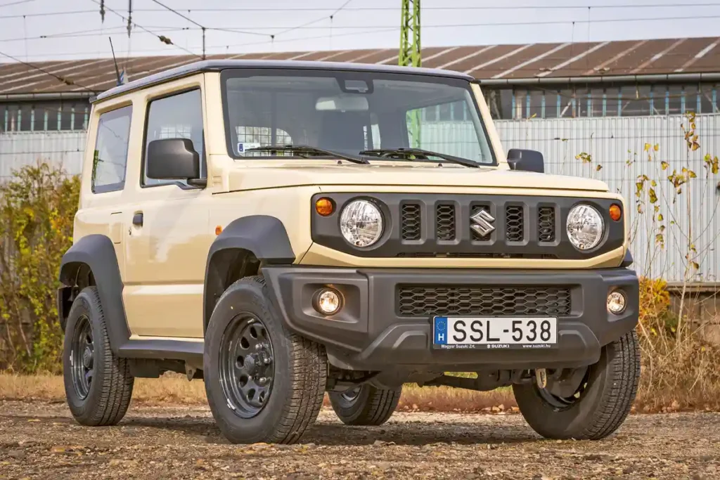 Kedves jelenség a Suzuki Jimny, a 15 colos lyukacsos lemezfelni szerintünk jobban mutat rajta, mint a 16-os alu. A hasmagasság 210 mm, diódás fényszóró az LCV-hez nincs