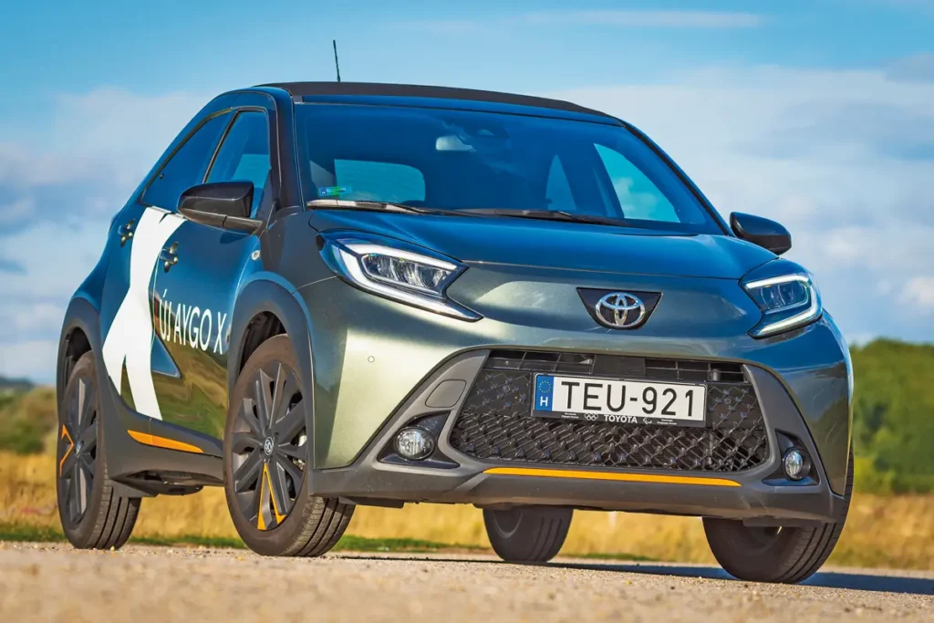 A Tyota Aygo X tetszetős, szerethető a formája és feltűnő színek is választhatók. A fotó csalóka, a hasmagasság csupán 146 mm