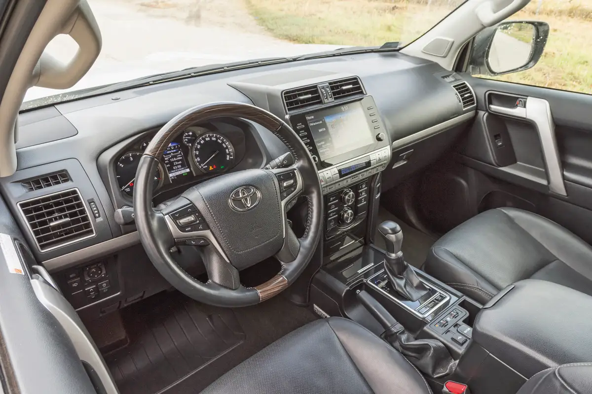 A Toyota Land Cruiser mindent megad, amire szükség lehet, de a környezet nem prémium színvonalú. A középső kartámasz alatt hűtődoboz van