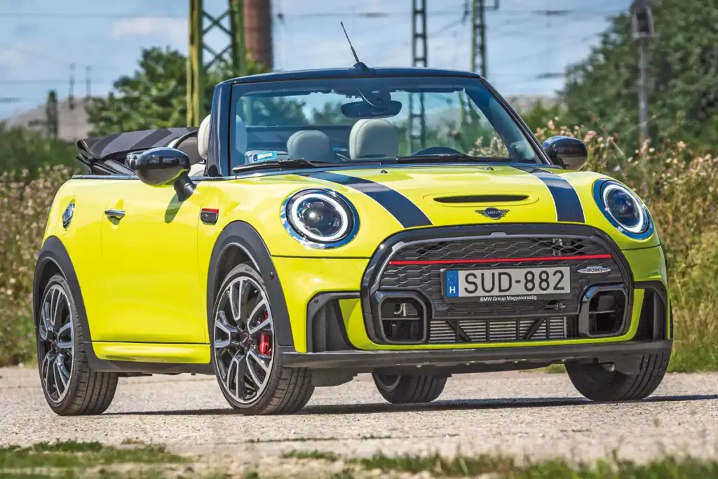 Viccelhetnénk, hogy a Mini John Cooper Works Cabrio-nak nagy lett a szája, igaz, jól is nyomja a szöveget. A piros csík és féknyereg JCW dizájnelem, az adaptív LED fényszórókért fizetni kell