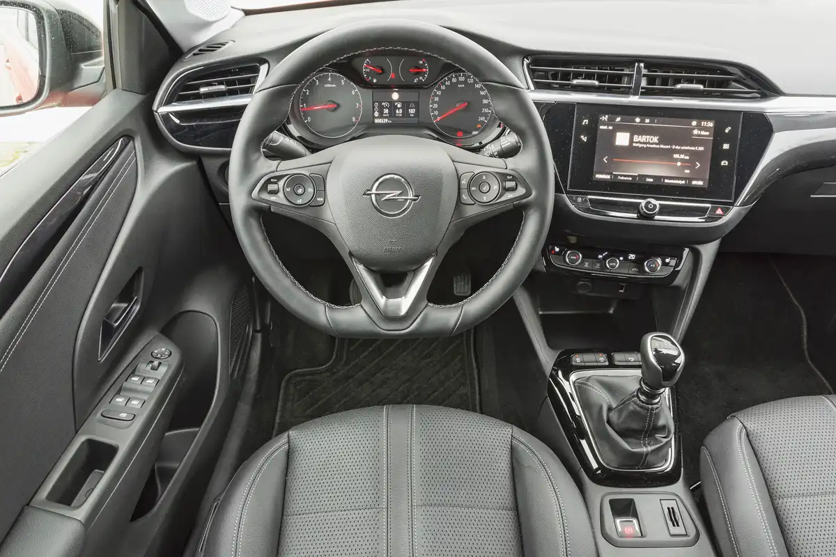 Opel-szabvány szerinti az analóg műszeregység, a két bajuszkapcsoló és a kormány, minden más PSA-alkatrész. A vészvillogót az utas is könnyen eléri, a középkonzolra tett központi zár rossz helyen van